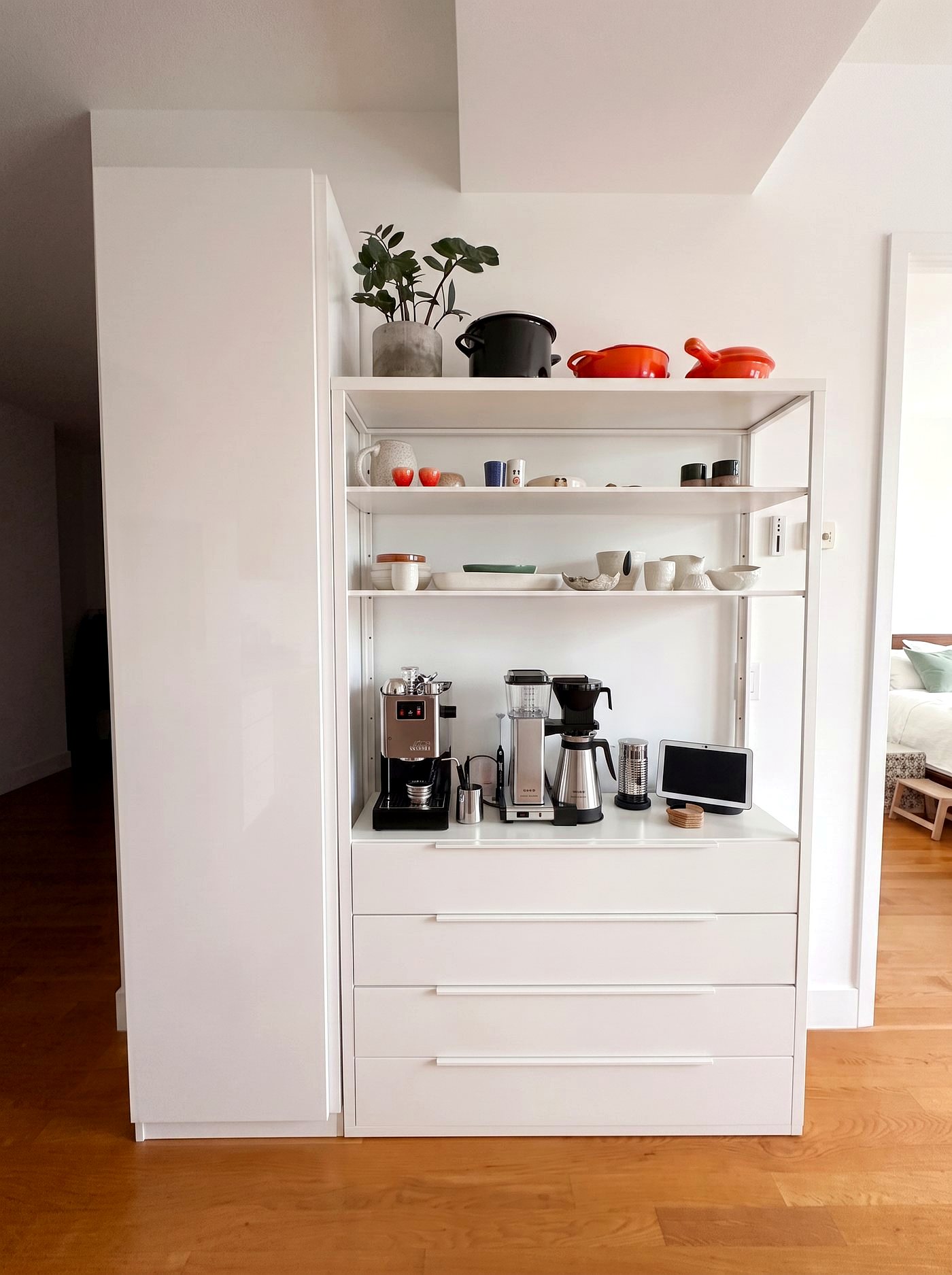 White built-in coffee station with ceramics displayed on open shelves above
